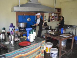 a man and woman in a kitchen preparing food at Mystique Highland Resort in Astam