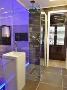 uma casa de banho com uma cabina de duche em vidro e um lavatório. em Maga Mirì Relais Suite em Spinazzola