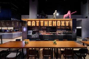 a dining room with a table and chairs at Moxy Taichung in Taichung
