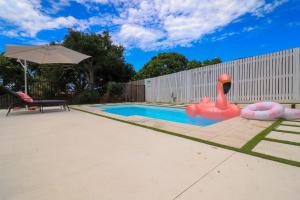 Pet Friendly Sleeps 8 Bowen Holiday House في بوين: مسبح بجعة قابلة للنفخ في ساحة