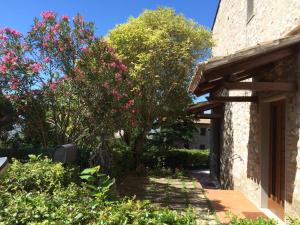 un jardín junto a un edificio con flores rosas en Casa Elena, en Asís