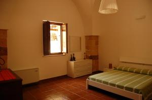 1 dormitorio con cama y ventana en Masseria Convento, en Novoli