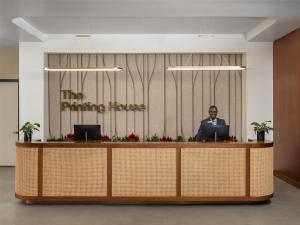 a man sitting at a reception desk with a laptop at The Printing House Hotel, Tapestry Collection By Hilton in Nashville
