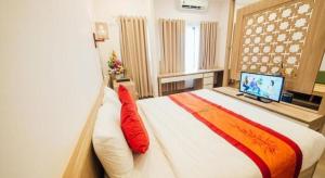Un dormitorio con una cama grande y un televisor. en Green Hotel Da Nang, en Da Nang