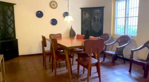 a dining room with a wooden table and chairs at Malgedara in Badulla