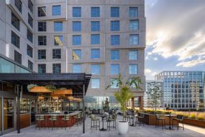 a patio with tables and chairs in front of a building at The Printing House Hotel, Tapestry Collection By Hilton in Nashville
