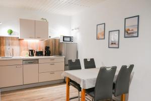 a kitchen and dining room with a table and chairs at Dünenhaus Fewos - Zum Strand 50m in Ueckeritz +17 photos