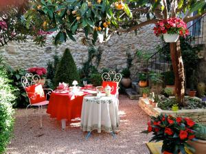 uma mesa e cadeiras num jardim com flores em La Maison du Peintre en Provence em Mallemort