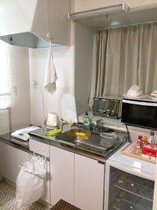 a kitchen with a sink and a microwave at Aun in Nagano