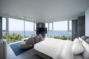 um quarto com uma cama e vista para o oceano em Hotel Hound Gangneung Gyeongpo em Gangneung