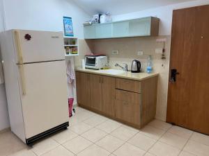a kitchen with a white refrigerator and a microwave at Apartment for 4 guests in Karmiel