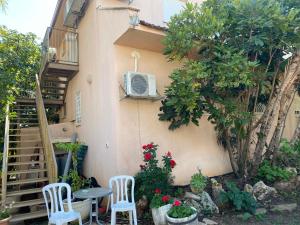 a patio with two chairs and a table in front of a building at Apartment for 4 guests in Karmiel