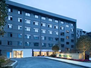 a large building with a parking lot in front of it at Ibis Styles Chengdu Chunxi Taikoo Li Hotel in Chengdu