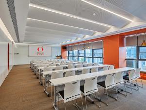 南京桔子酒店（南京江宁东南大学诚信大道店）的一间设有一排桌椅的会议室