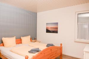 a bedroom with two beds and a window at Dünenhaus Fewos - Zum Strand 50m in Ueckeritz