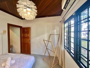 Un dormitorio con una cama y una lámpara de araña en Chic Double Room Shared Bungalow near LRT SS1 PJ, en Petaling Jaya