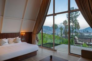 a bedroom with a bed and a large window at Triangle Valley in Ooty