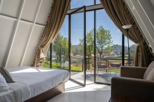 a bedroom with a bed and a large window at Triangle Valley in Ooty +27 photos