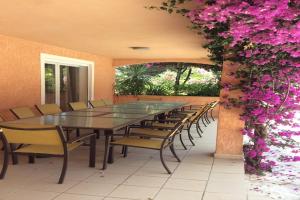 a long table and chairs with pink flowers on a wall at Cosy holiday home in Tuscany with shared swimming pool in San Casciano in Val di Pesa