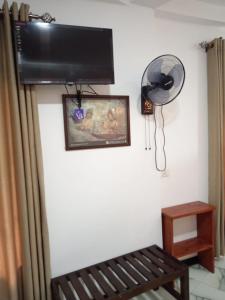 um quarto com um ventilador na parede e um banco em Forest Paddy Homestay em Ella