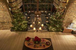 a room with three christmas trees and christmas decorations at Kempinski Hotel Berchtesgaden in Berchtesgaden