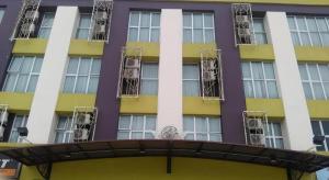 a yellow and purple building with fire escapes at Grand Medallion Hotel in Kampong Tabuan