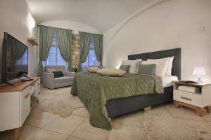 una camera da letto con un letto, un divano e una televisione di White Swan Boutique Apartments a Praga