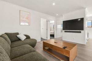 a living room with a couch and a coffee table at Within Range in Papamoa