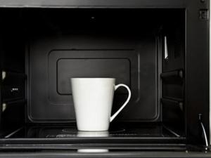 a white coffee cup sitting in a microwave at Hotel Crown Hills Takaoka in Takaoka