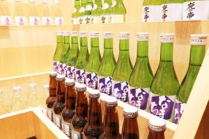 a bunch of bottles on a shelf in a store at Miyajima Morinoyado in Miyajima