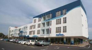 a large white building with cars parked in a parking lot at Hotel Zamburger Segamat (Previously Koptown Hotel Segamat) in Segamat +67 photos