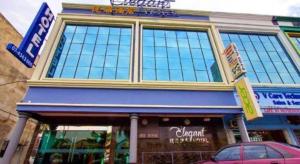 a store front with a car parked in front of it at Elegant Hotel in Kampong Linau