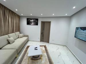 a living room with a couch and a tv at Studio pearl pyramids in Ghaţāţī +8 photos