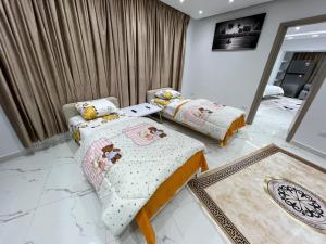 a bedroom with two beds and a mirror at Studio pearl pyramids in Ghaţāţī