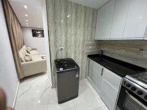 a small kitchen with a stove and a couch at Studio pearl pyramids in Ghaţāţī