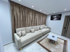 a living room with a couch and a table at Studio pearl pyramids in Ghaţāţī