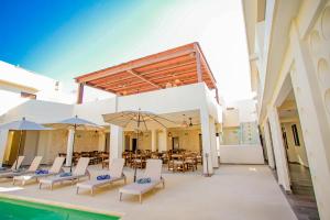 Nuxká Hotel في تيلشاك بويرتو: فناء مع كراسي وطاولات ومسبح