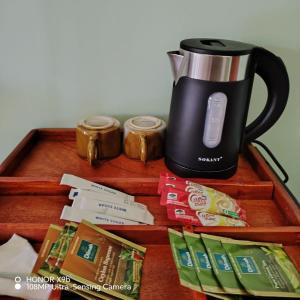 a coffee maker sitting on top of a wooden table at Zen Garden Palace in Ella