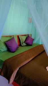 a bed with colorful pillows on it in a tent at Zen Garden Palace in Ella