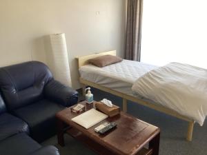 una habitación con una cama, una silla y una mesa en Katsuura Seaside Hotel, en Nachikatsuura 3 fotos más