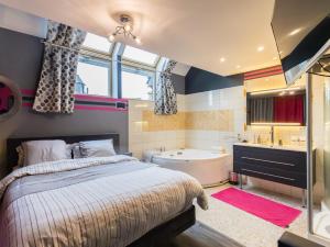 ガンガンにあるTi harmonielのベッドと浴槽と洗面台のある寝室