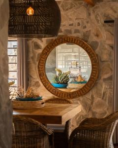 a mirror on a stone wall with a table and chairs at Twyfelberg Karoo Hideaway in Britstown +92 photos