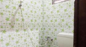 baño con aseo y flores verdes en la pared en Hotel O Mountain View Homestay, en Tomohon 40 fotos más