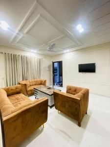 un salon avec deux canapés et une télévision dans l'établissement Lower canal 1 BHK secure area, à Faisalabad