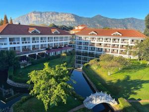 an aerial view of a resort with a river and a building at Kunming Dianchi Garden Hotel & Spa in Kunming