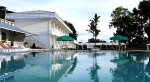 Toba Beach Hotel في Tomok: حمام سباحة كبير أمام مبنى