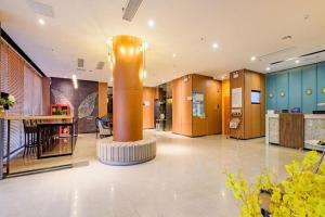 a lobby with a column in the middle of a building at GME NanJing CaoChanGMEn Nanyihou Stress Hotel in Nanjing