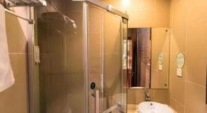 a bathroom with a glass shower and a sink at GreenTree Inn Changshu South HaiYu Road Pedestrian Street Business Hotel in Changshu