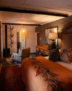 a bedroom with a bed and a couch and a table at Twyfelberg Karoo Hideaway in Britstown