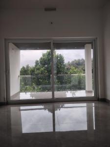 ein leerer Raum mit einem großen Fenster mit Aussicht in der Unterkunft Savisos home in Padinjarathara